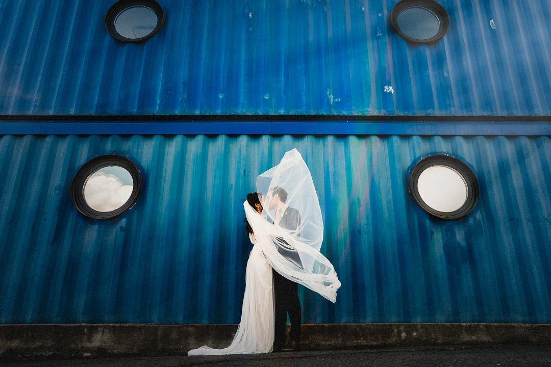 a couple kiss obscured by the brides veil at trinity buoy wharf in London